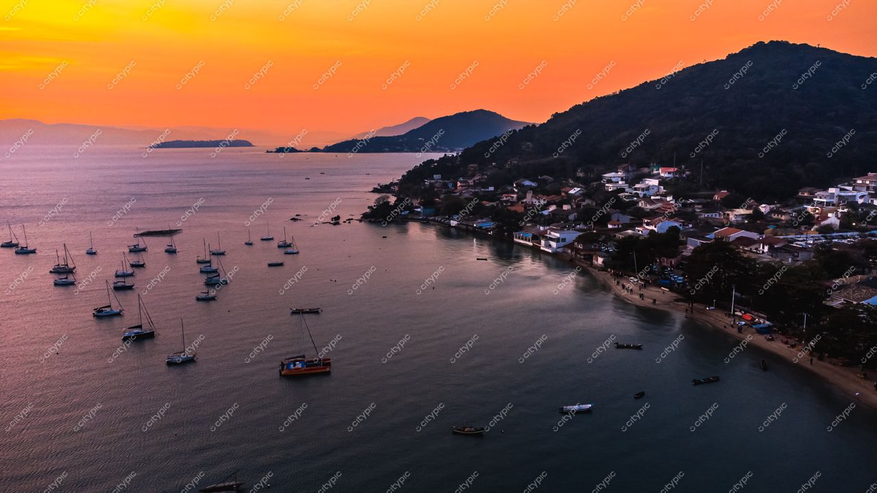 Florianópolis, Santa Catarina vista panorâmica ao pôr do sol com barcos à vela e vegetação nas encostas montanhosas