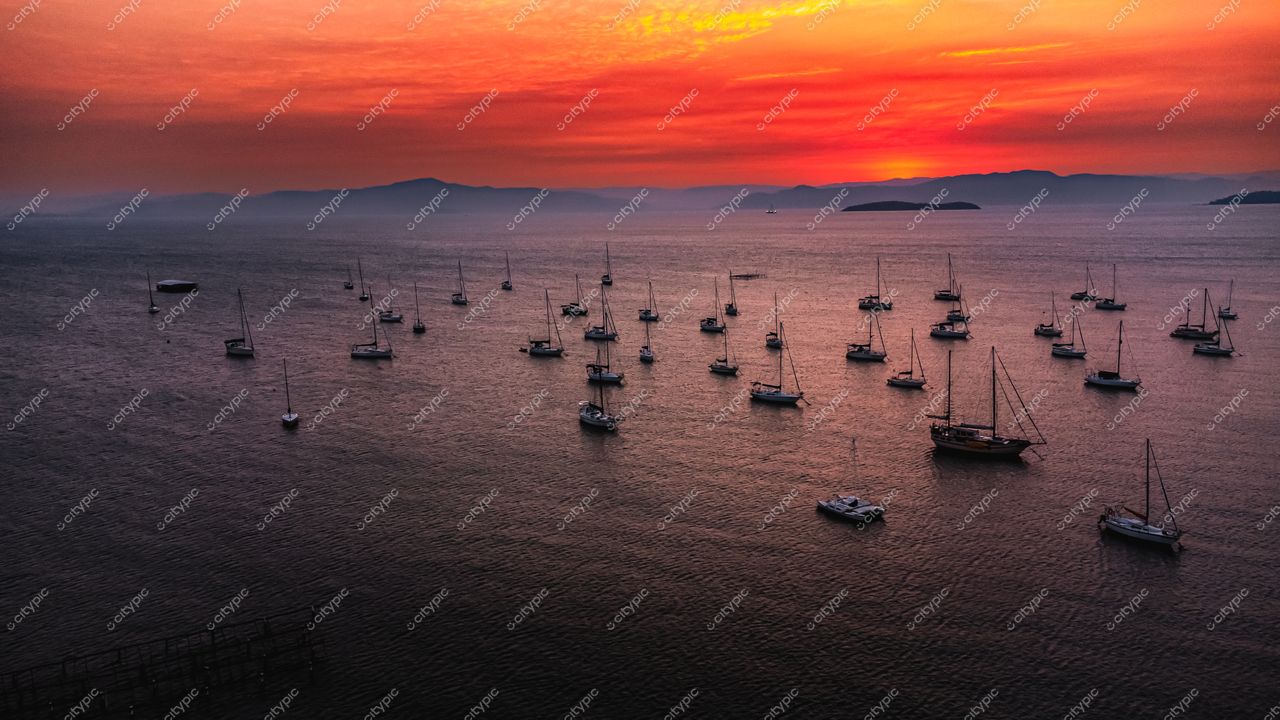 Florianópolis, Santa Catarina, vista panorâmica do pôr do sol com embarcações à vela e montanhas ao fundo