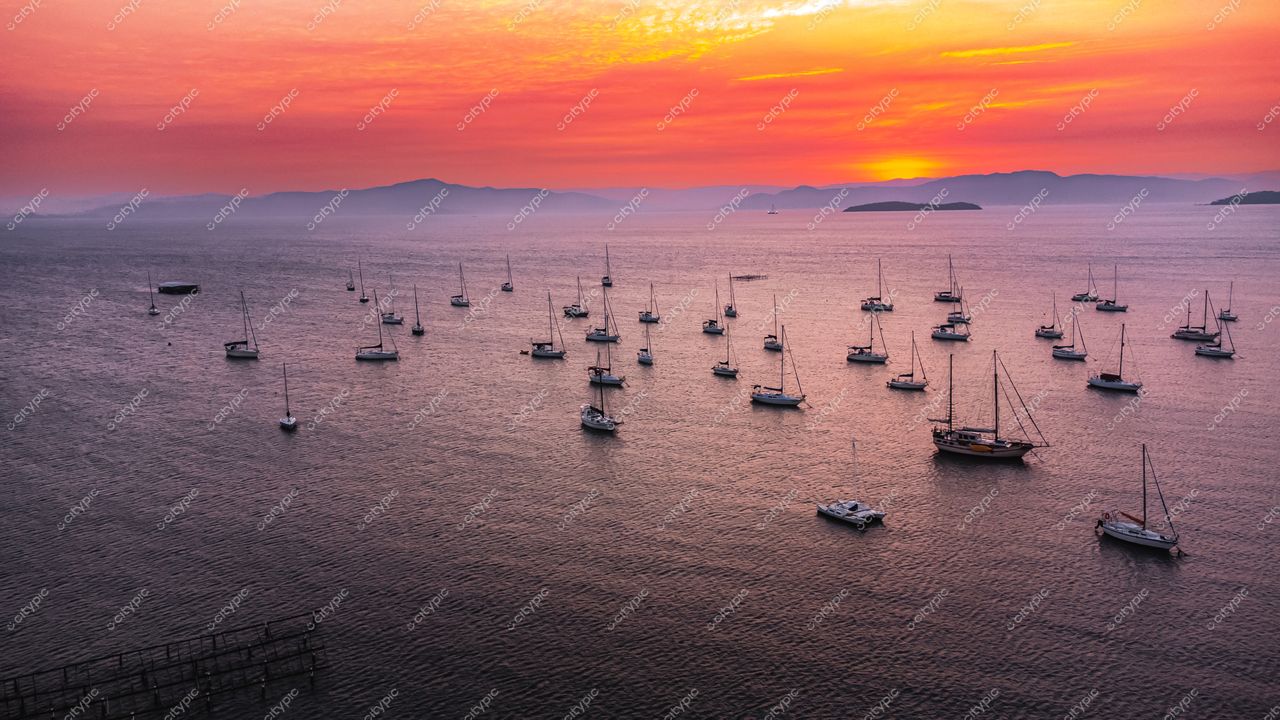 Florianópolis, Santa Catarina, pôr do sol vibrante com embarcações à vela e montanhas ao fundo em tranquilidade