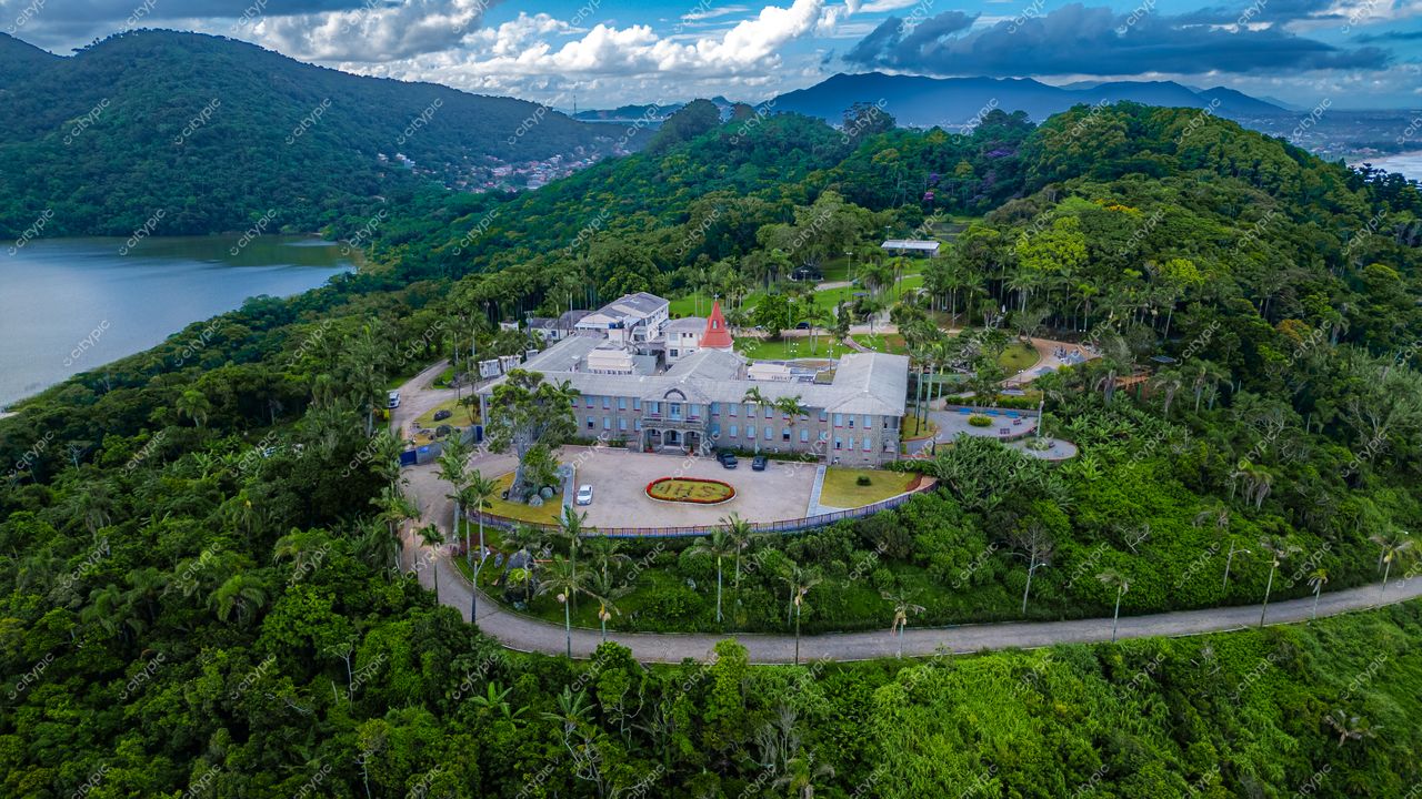 Morro das Pedras e Lagoa do Peri em Florianópolis com construção notável cercada por vegetação densa e montanhas ao fundo
