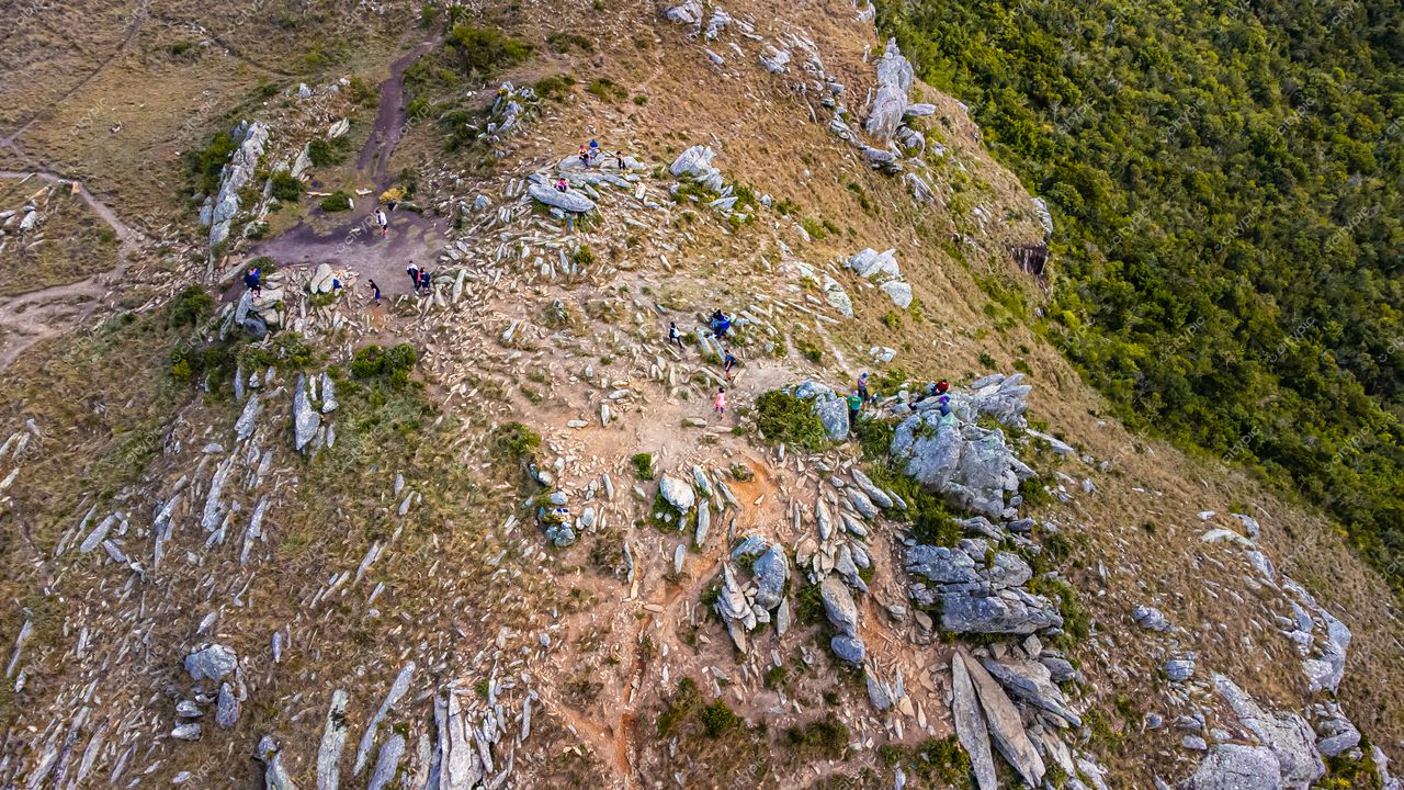 Lagoinha do Leste em Florianópolis com vista aérea destacando rochas expostas, vegetação rasteira e trilhas movimentadas
