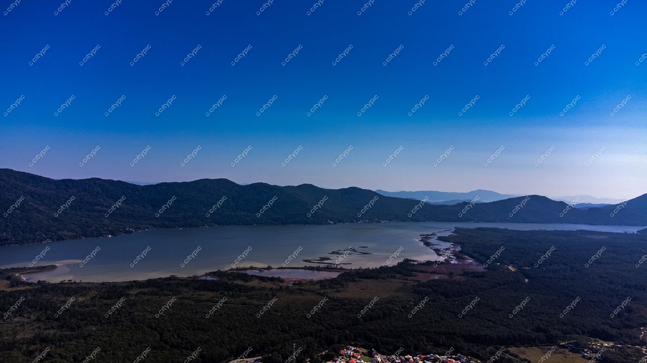 Barra da Lagoa em Florianópolis com vista aérea destacando montanhas, vegetação densa e canais na água tranquila