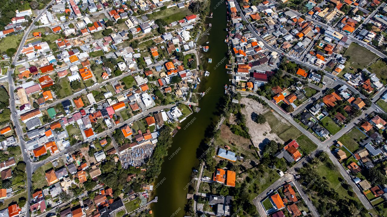 Barra da Lagoa em Florianópolis com casas coloridas, canal serpenteante e vegetação sob luz do dia
