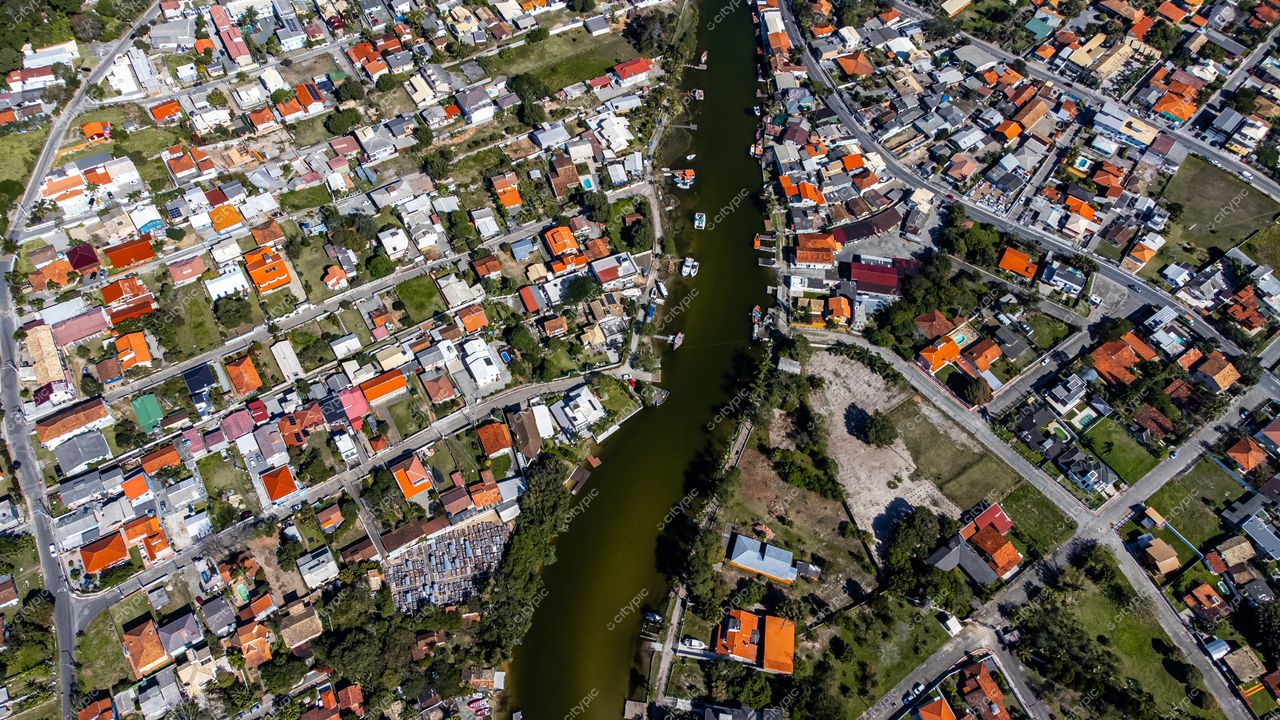 Barra da Lagoa em Florianópolis com casas de telhados coloridos e canal central entre vegetação e edificações