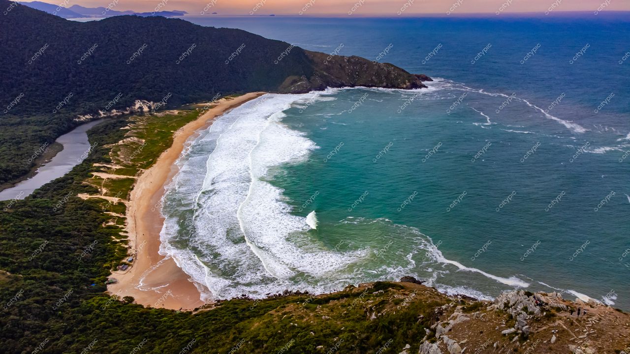 Lagoinha do Leste em Florianópolis com vista aérea ao entardecer mostrando praia, vegetação densa e montanhas