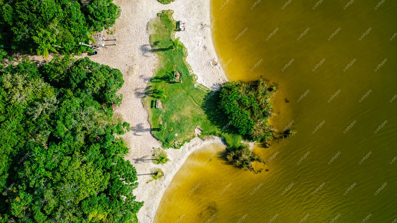 Morro das Pedras e Lagoa do Peri em Florianópolis com vegetação densa e bancos de madeira na orla clara