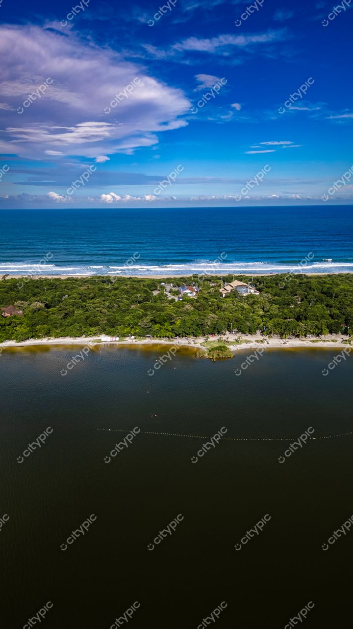 Morro das Pedras e Lagoa do Peri em Florianópolis com vegetação densa e construções residenciais à beira da água