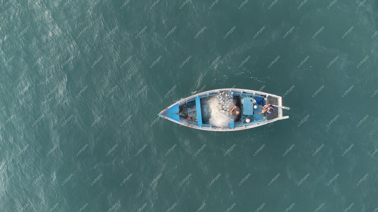 Florianópolis, Santa Catarina, ângulo aéreo de embarcação pesqueira em águas tranquilas com reflexos claros durante o dia