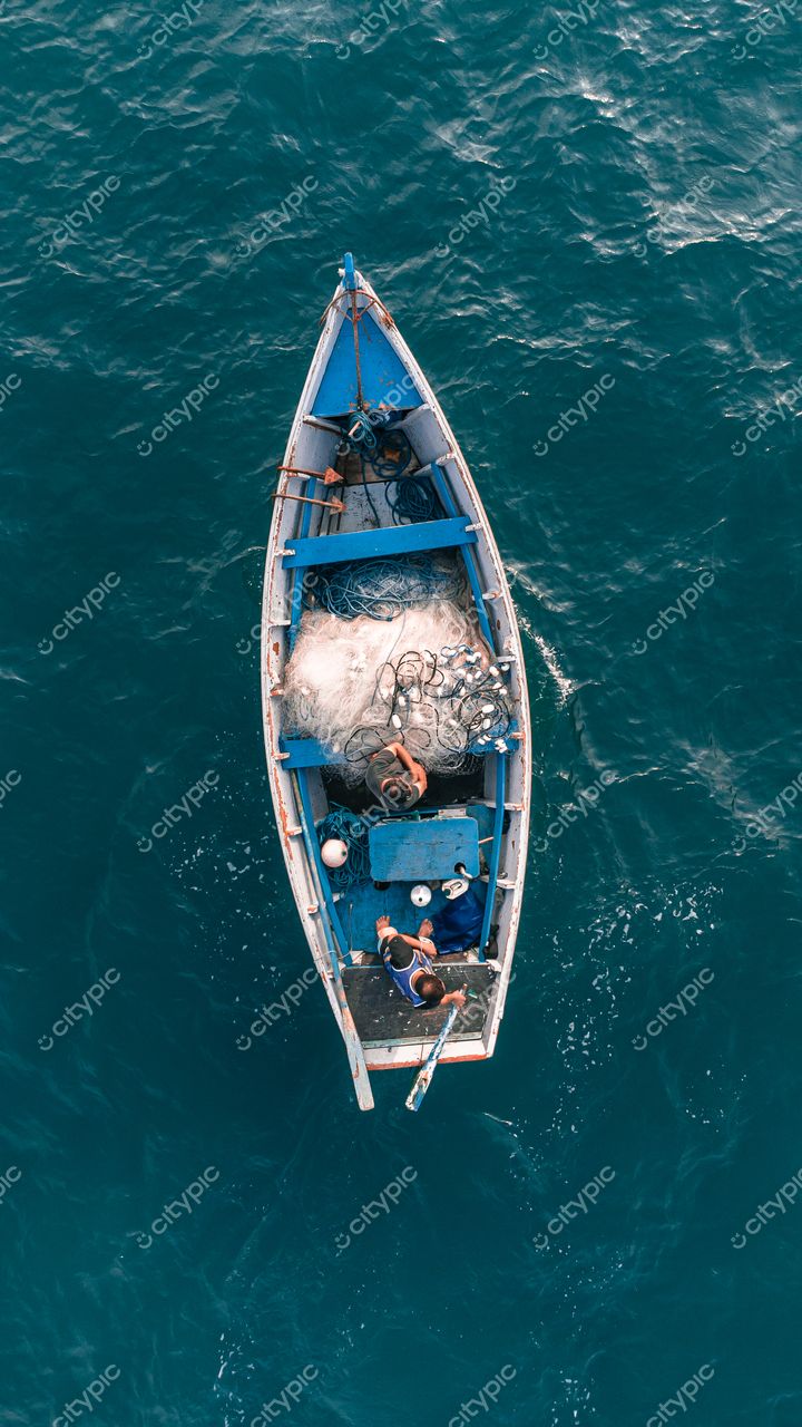 Florianópolis, Santa Catarina, vista aérea de embarcação de pesca azul com redes e pessoas em dia ensolarado