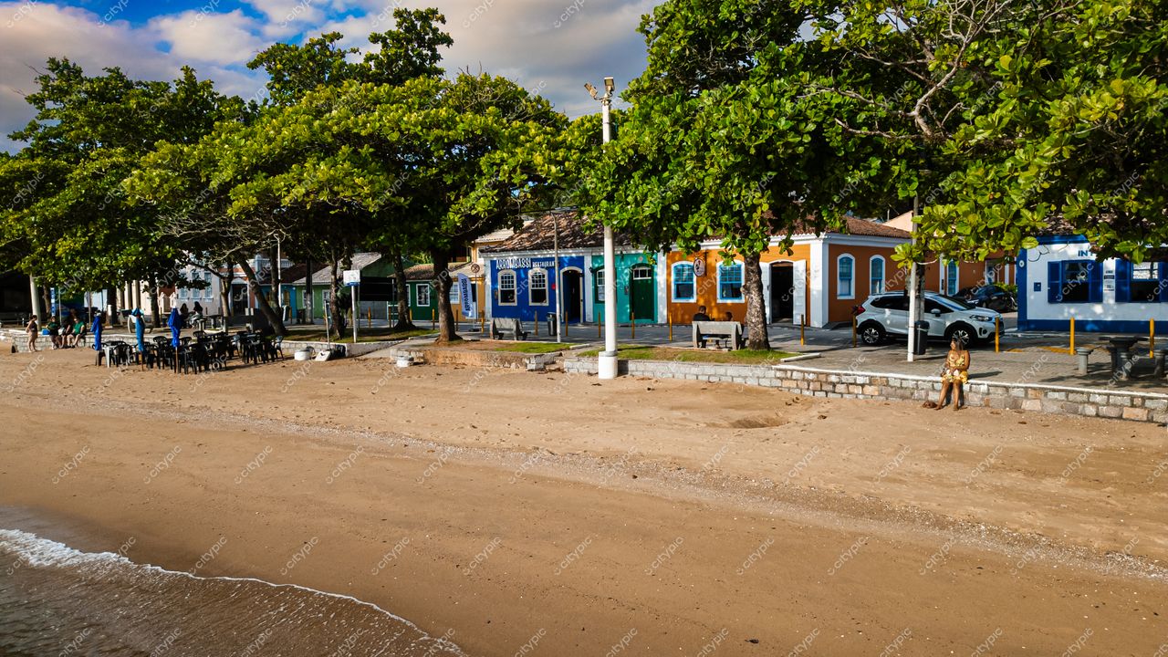 Ribeirão da Ilha, em Florianópolis, vista da praia com casas coloridas e ambiente tranquilo em dia ensolarado