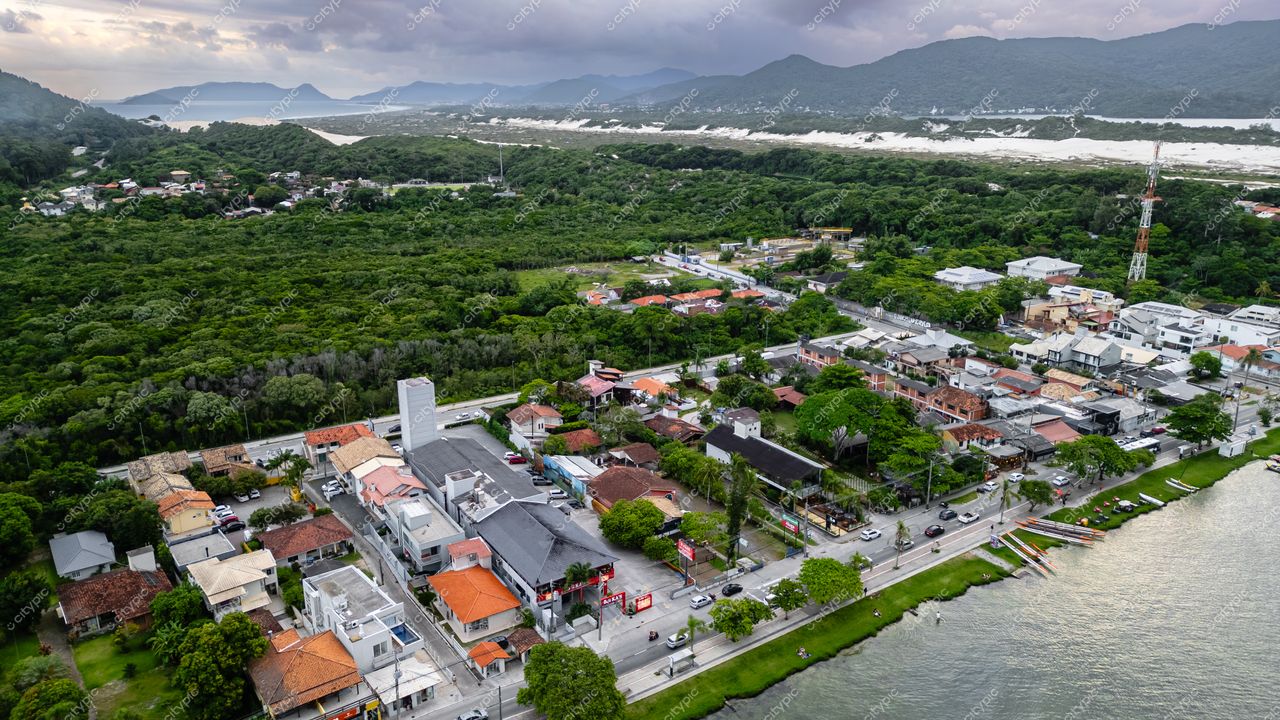 Rendeiras em Florianópolis com vista aérea de áreas urbanas, vegetação densa e céu nublado ao fundo