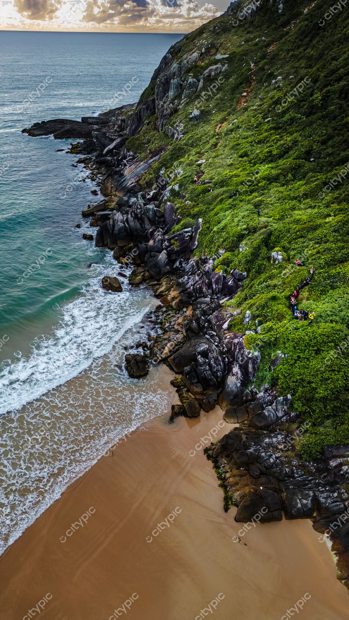 Lagoinha do Leste em Florianópolis com vista aérea ao pôr do sol e pessoas na trilha entre a vegetação