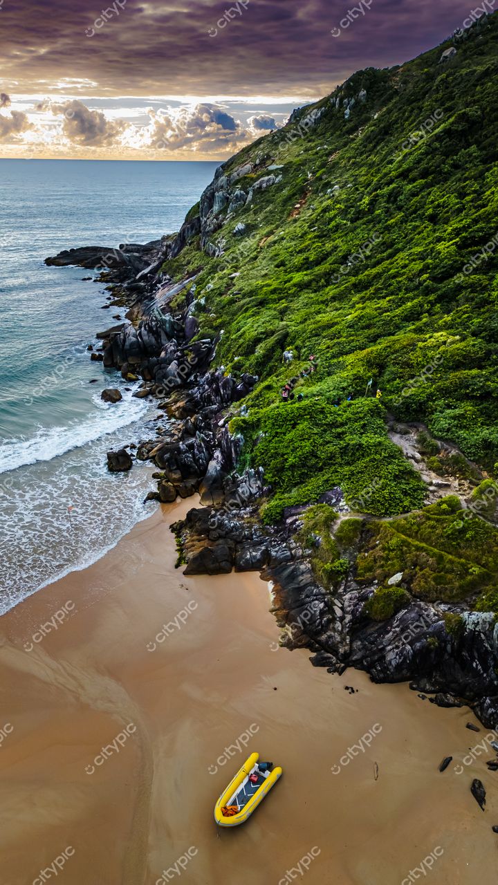 Lagoinha do Leste em Florianópolis com barco inflável amarelo na areia e vegetação exuberante ao entardecer