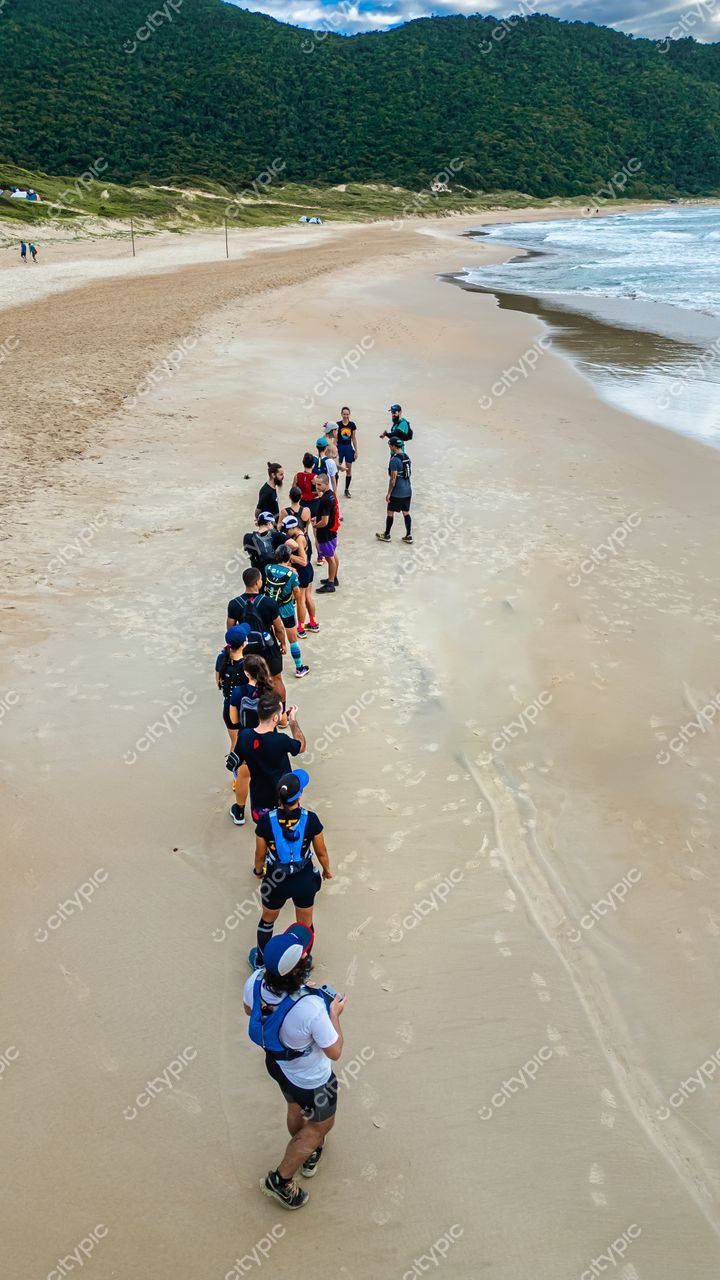 Lagoinha do Leste em Florianópolis com grupo de pessoas caminhando na praia sob luz natural durante o dia