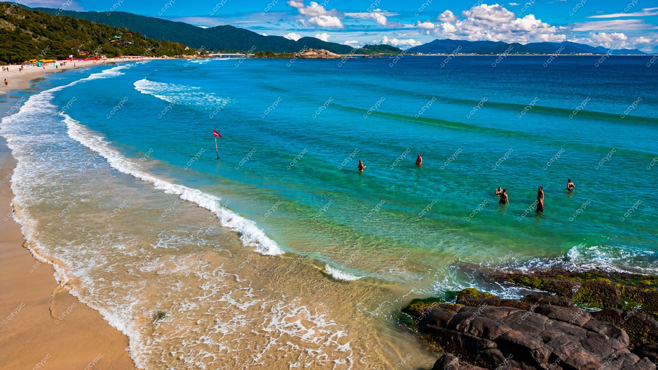 Lagoinha do Leste em Florianópolis com águas azul-turquesa, areia clara e vegetação ao fundo em dia ensolarado
