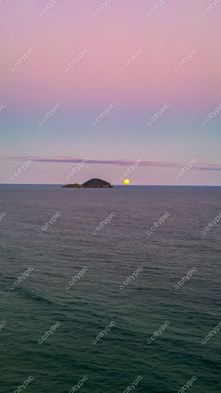 Praia do Moçambique em Florianópolis com crepúsculo suave e ilhéu ao fundo refletindo no mar calmo