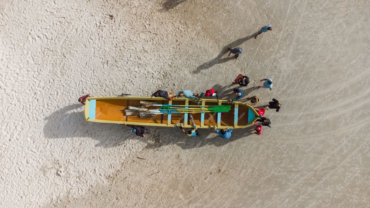 Florianópolis, Santa Catarina, vista aérea de pessoas organizando remos ao redor de canoa colorida na areia clara
