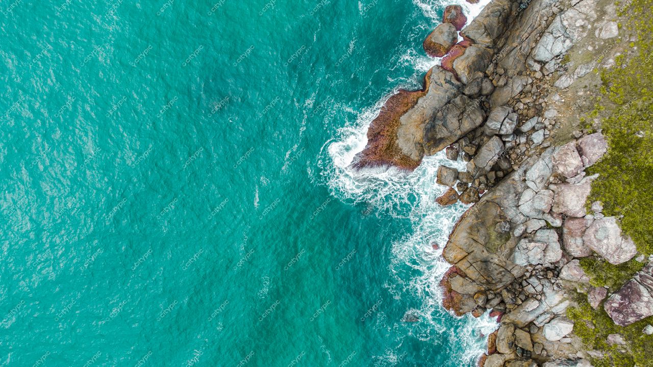 Florianópolis, Santa Catarina, costa com águas cristalinas e rochas expostas em dia ensolarado e relevo acidentado