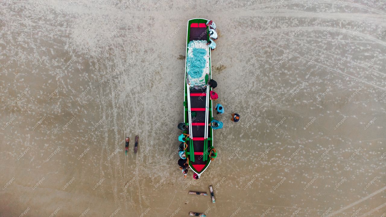 Florianópolis, Santa Catarina, embarcação colorida ancorada na areia com pessoas interagindo em ambiente tranquilo e céu nublado