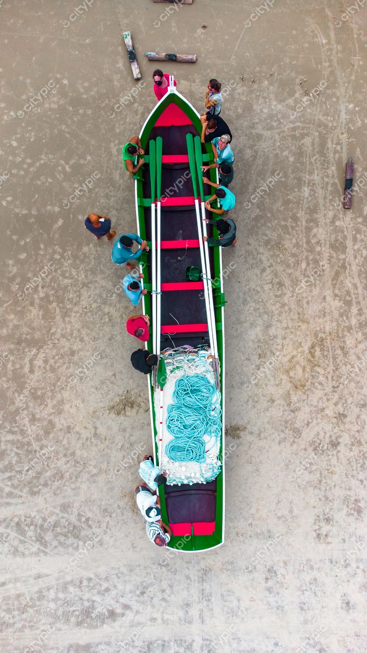 Florianópolis, Santa Catarina, embarcação colorida sendo preparada na areia por grupo de pescadores em ambiente tranquilo