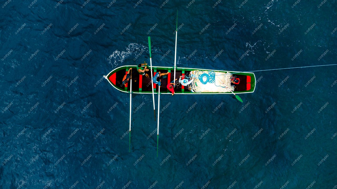Florianópolis, Santa Catarina vista aérea de canoa tradicional verde e vermelho em águas azuis com pessoas a bordo