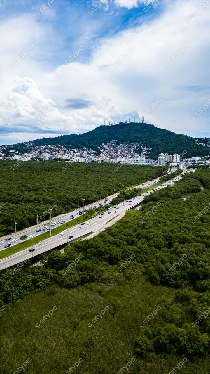 Hospital SOS Cárdio em Florianópolis com vista panorâmica de rodovia, vegetação densa e morro ao fundo
