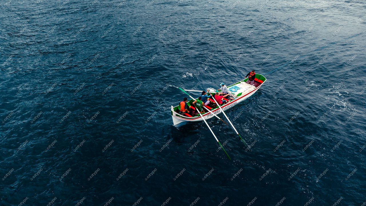 Florianópolis, Santa Catarina grupo de pessoas remando em barco colorido em mar azul sob céu nublado e tranquilo