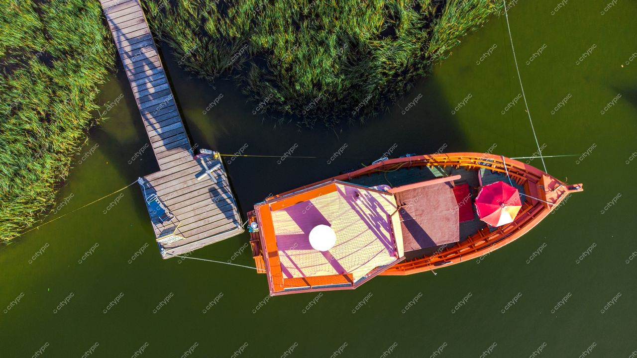 Florianópolis, Santa Catarina vista aérea de barco colorido ancorado em águas calmas com vegetação e píer de madeira