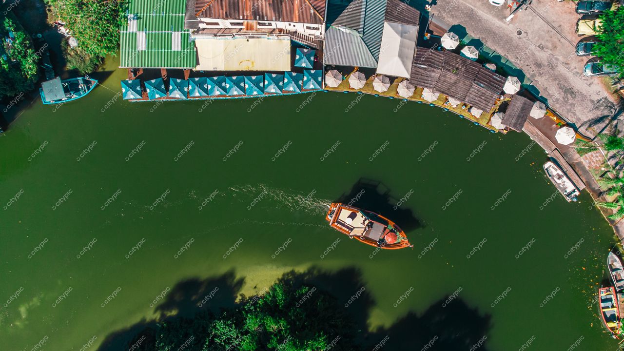 Florianópolis, Santa Catarina, vista aérea de canal com embarcação e quiosques em meio à vegetação densa