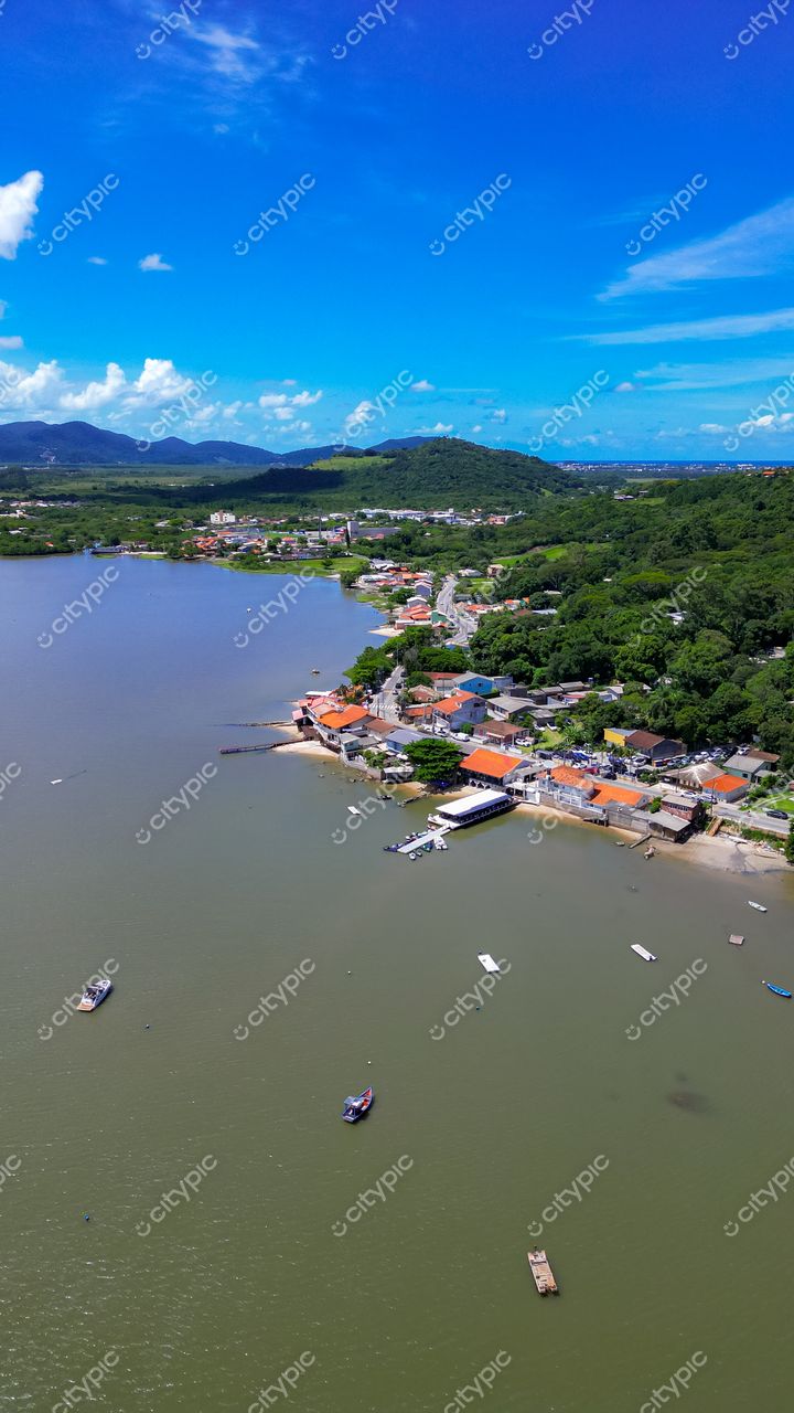 Ribeirão da Ilha em Florianópolis com vista aérea de baía tranquila, vegetação abundante e casas de telhados terrosos