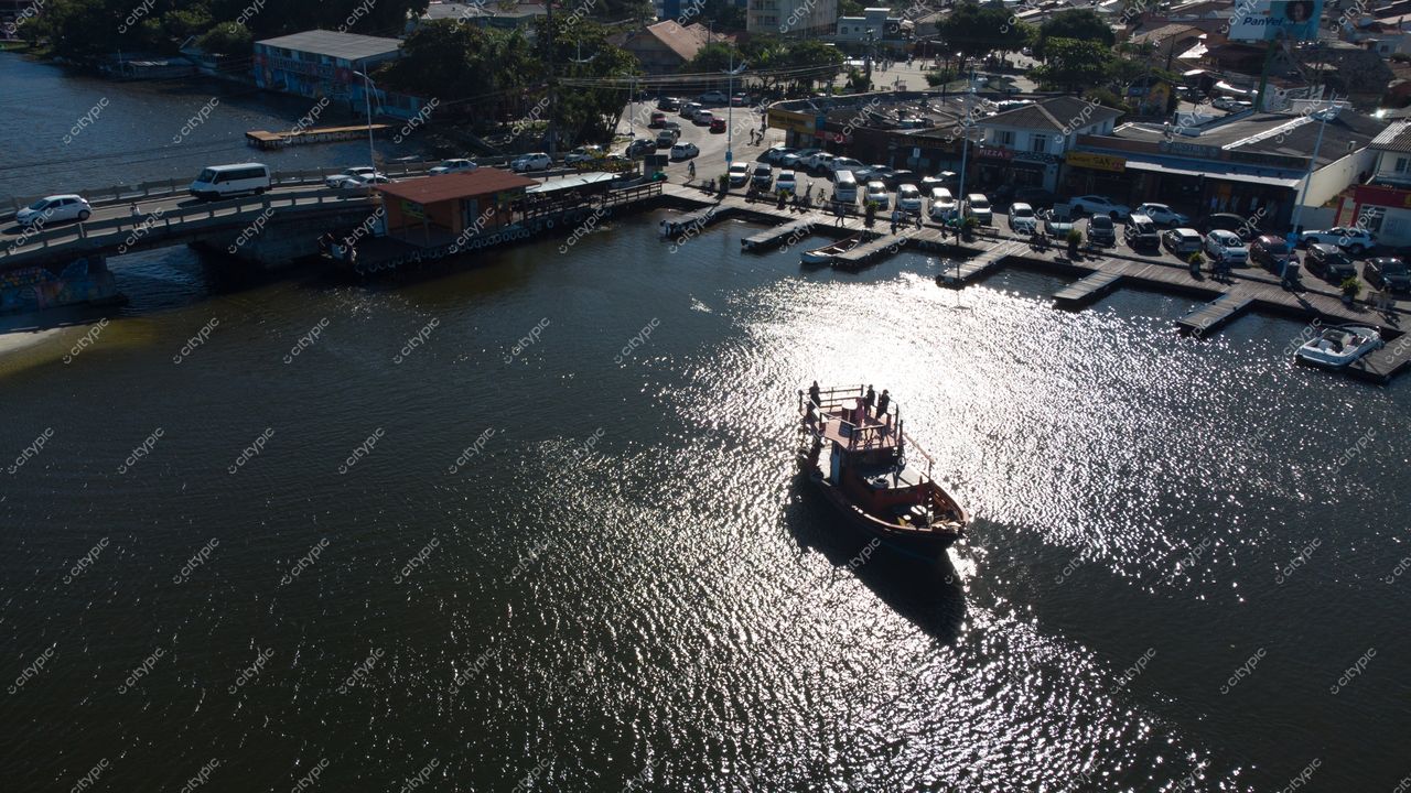 Florianópolis, Santa Catarina vista aérea com barco no canal e vegetação ao fundo em dia ensolarado