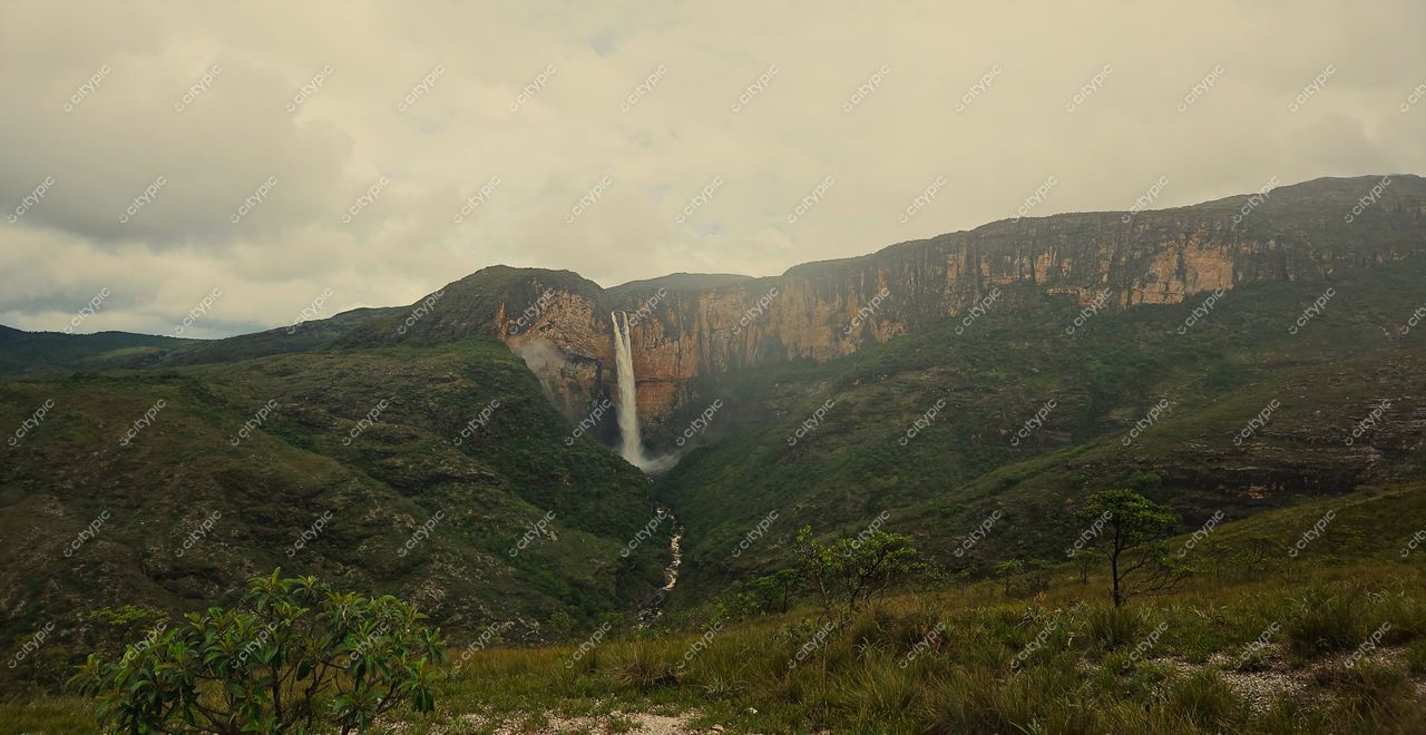 Conceição do Mato Dentro, Minas Gerais, cachoeira em relevo montanhoso com vegetação densa e iluminação suave de dia nublado