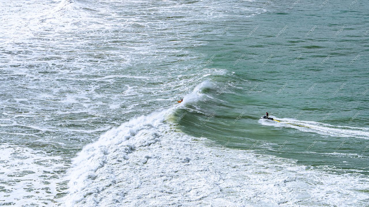 Lagoinha do Leste em Florianópolis com surfista e moto aquática em dia ensolarado e ondas movimentadas