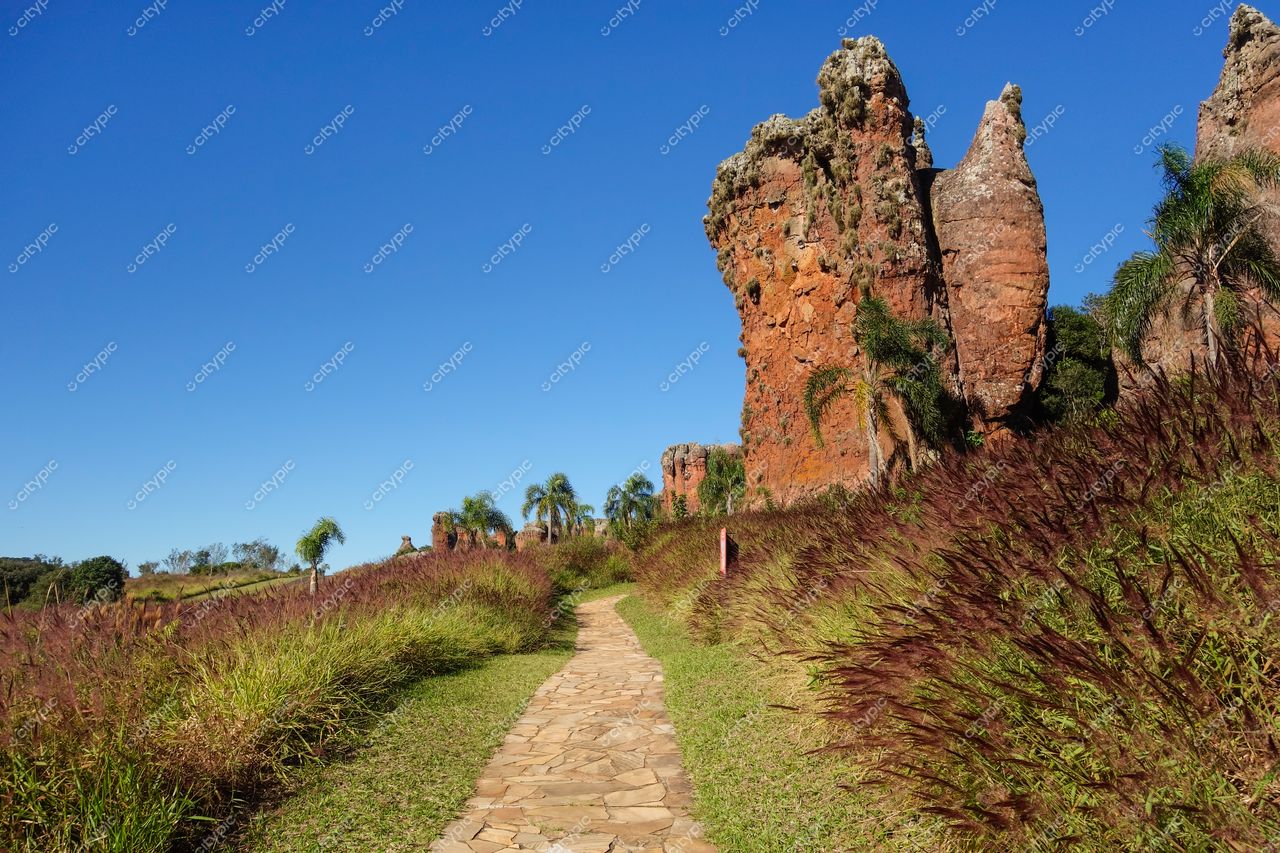 Ponta Grossa, Paraná caminho de pedra entre formações rochosas avermelhadas e vegetação exuberante em dia ensolarado