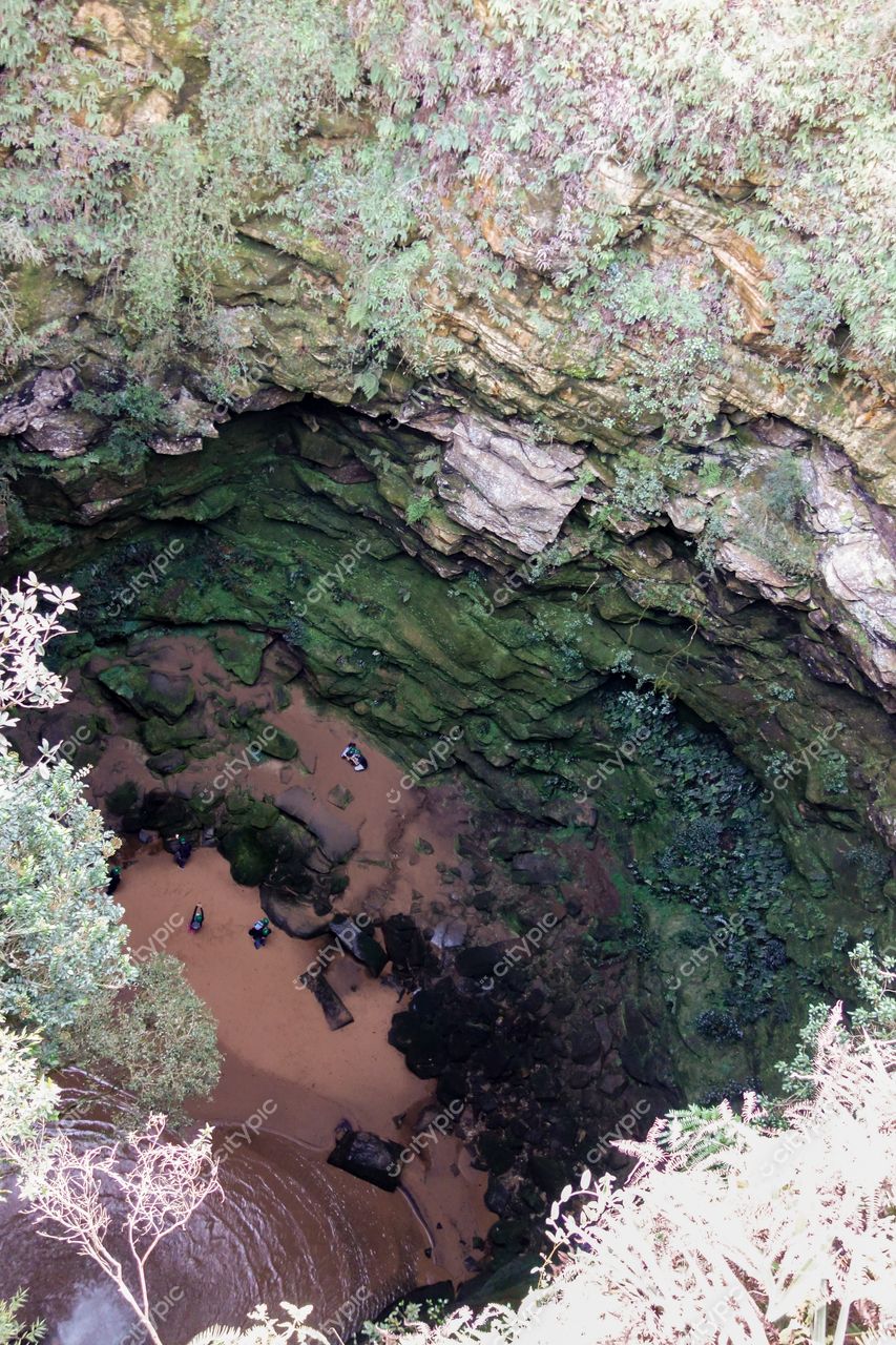 Ponta Grossa, Paraná vista aérea de buraco natural com vegetação abundante e pessoas para escala em dia ensolarado