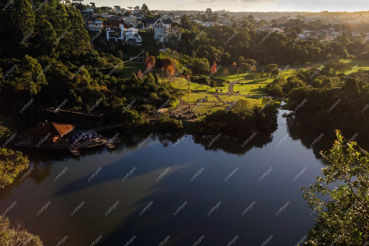 Curitiba, Paraná vista panorâmica de parque urbano ao amanhecer com lago calmo e edifícios residenciais ao fundo