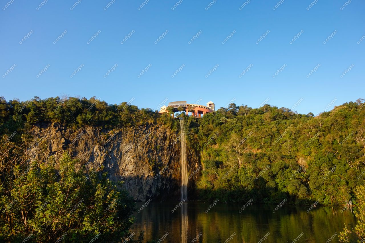 Curitiba, Paraná vista panorâmica com cascata em penhasco rochoso e lago refletindo céu azul em dia ensolarado
