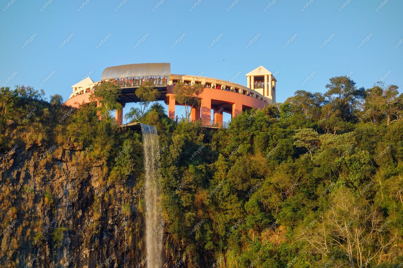 Curitiba, Paraná vista do mirante ao entardecer com estrutura arquitetônica, vegetação densa e cachoeira em destaque