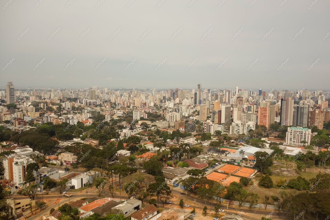 Curitiba, Paraná vista panorâmica com edifícios altos, áreas verdes e céu nublado em iluminação suave