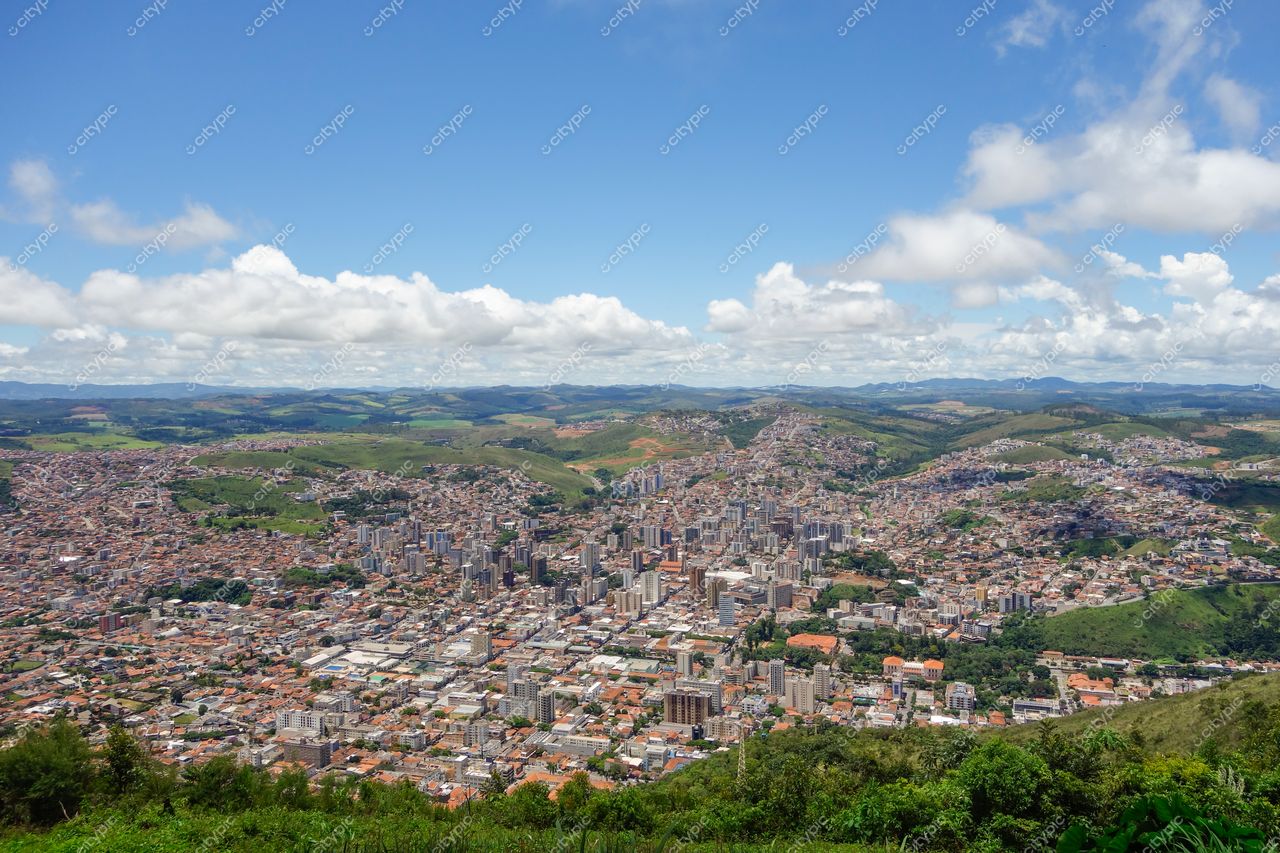Poços de Caldas, Minas Gerais em dia ensolarado com vista panorâmica da cidade entre montanhas e vegetação verdejante