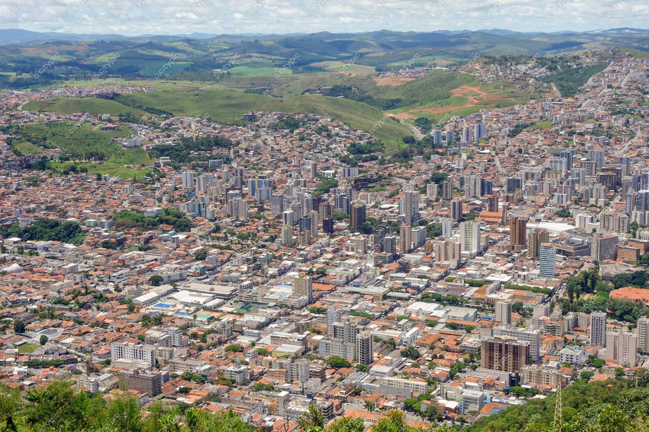 Poços de Caldas, Minas Gerais vista panorâmica com prédios altos e vegetação sob céu parcialmente nublado durante o dia