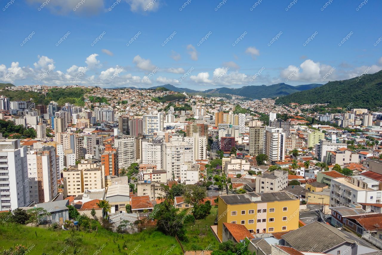 Poços de Caldas, Minas Gerais vista panorâmica em dia ensolarado com montanhas ao fundo e telhados avermelhados