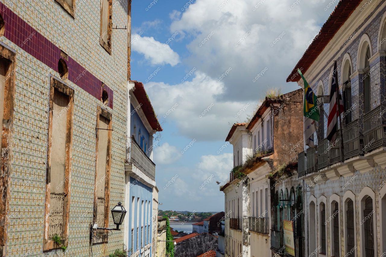 São Luís, Maranhão, vista de rua com arquitetura colonial e azulejos, céu azul e rio ao fundo durante o dia