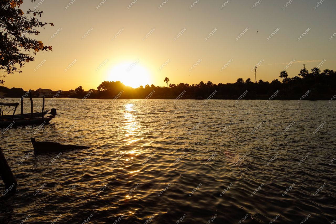 Barreirinhas, Maranhão, pôr do sol sobre o rio com reflexos dourados e vegetação local ao fundo