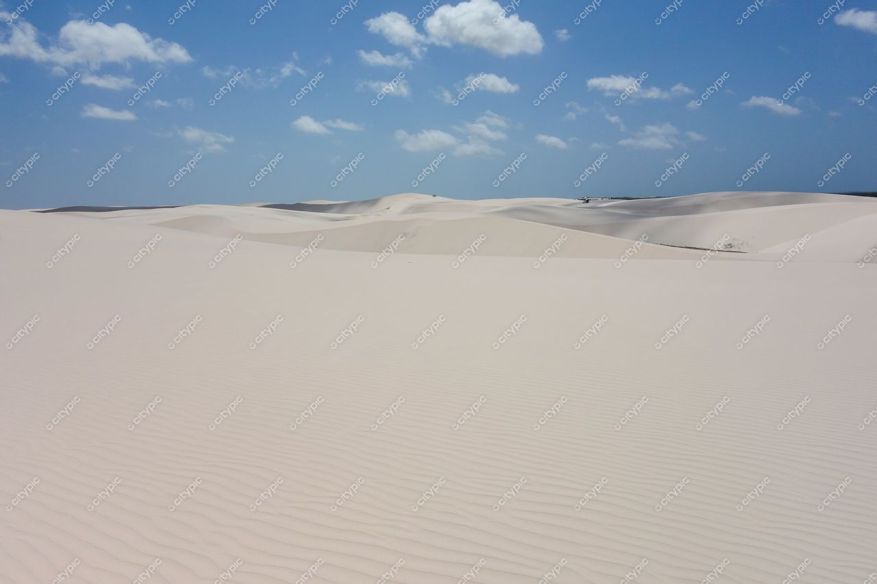 Lençóis Maranhenses, Maranhão, vastas dunas brancas sob céu azul com nuvens, iluminação natural durante o dia