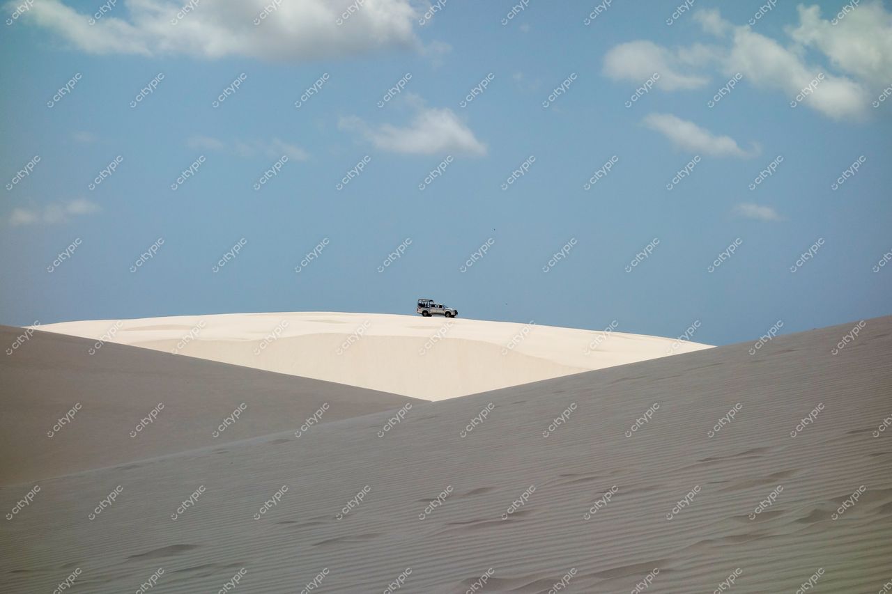 Lençóis Maranhenses, Maranhão, veículo off-road sobre duna branca sob céu parcialmente nublado e iluminação natural