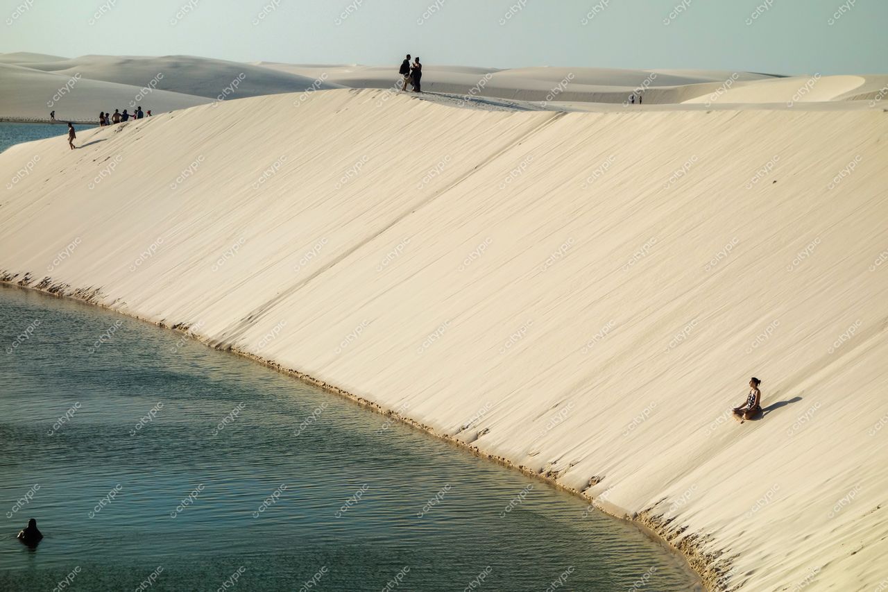 Lençóis Maranhenses, Maranhão, captura de dunas brancas e lagoas com pessoas explorando ao entardecer tranquilo