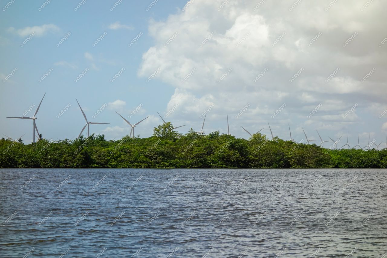 Atins, Maranhão, panorama com turbinas eólicas ao fundo e mangue refletindo luz do sol no rio