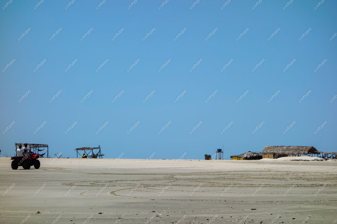 Atins, Maranhão vista tranquila com areia branca, céu claro, quiosque e quadriciclo em primeiro plano