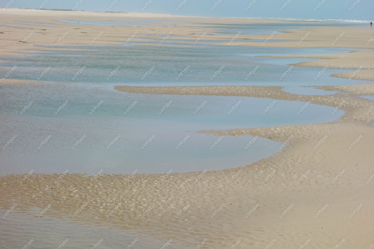 Atins, Maranhão ampla faixa de areia com água rasa refletindo luz do sol em dia claro e tranquilo